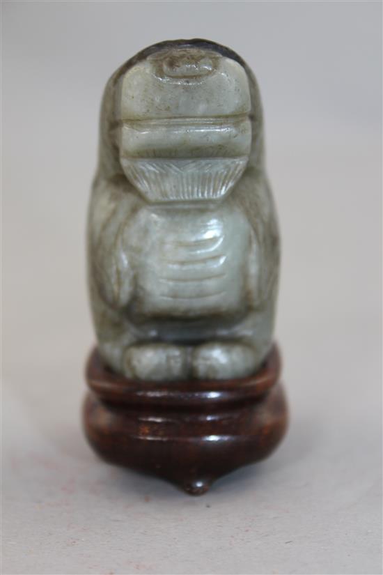 A Chinese pale grey and black jade carving of a lion-dog, Ming dynasty, 6cm., wood stand